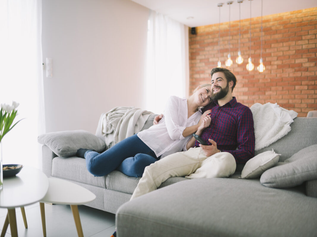 Sofá modular gris cómodo para sala moderna; pareja descansando en hogar de Medellín – Tufá muebles.
