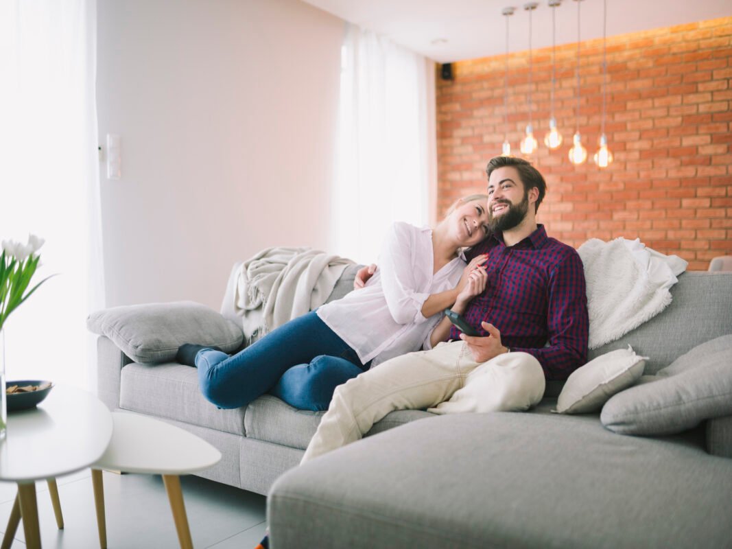 Sofá modular gris cómodo para sala moderna; pareja descansando en hogar de Medellín – Tufá muebles.