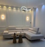 Sofá Tipo L C-H gris claro de Tufá Muebles en sala con lámpara moderna